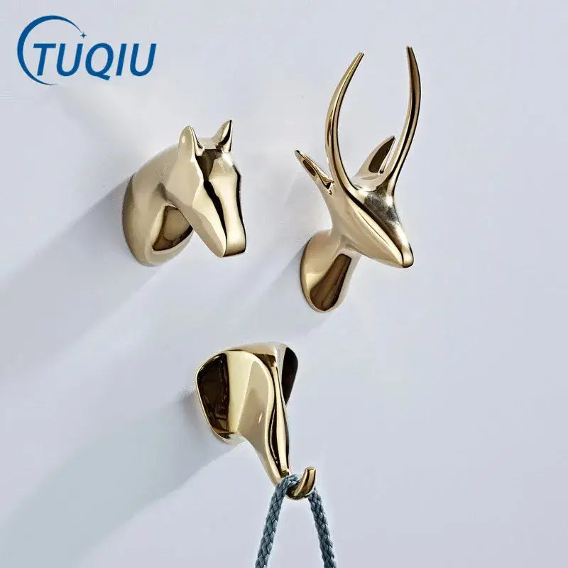 Vintage gold-colored decorbites brass robe hooks shaped like horse head, antlered deer, and elephant for wall decor