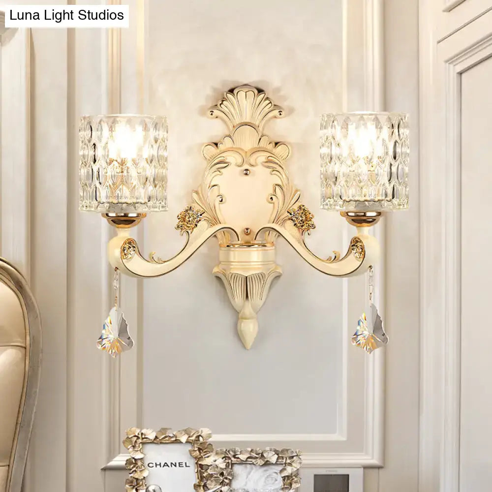 Elegant cream-colored vintage glass wall light with gold accents and two faceted crystal shades for bedroom use
