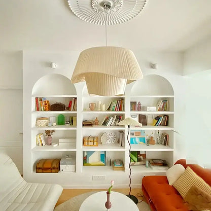 Vintage beige pleated pendant chandelier with cream wind fabric hanging above a white bookshelf decorbites cream wind