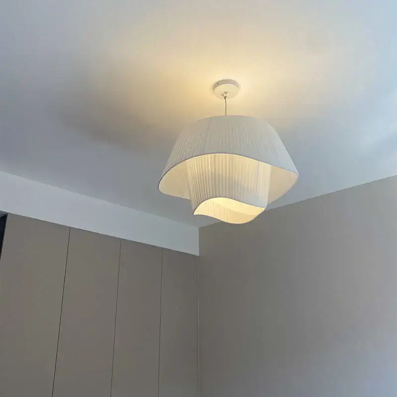 A modern white pleated pendant chandelier with cream wind fabric and soft diffused glow for bedroom decorbites decor