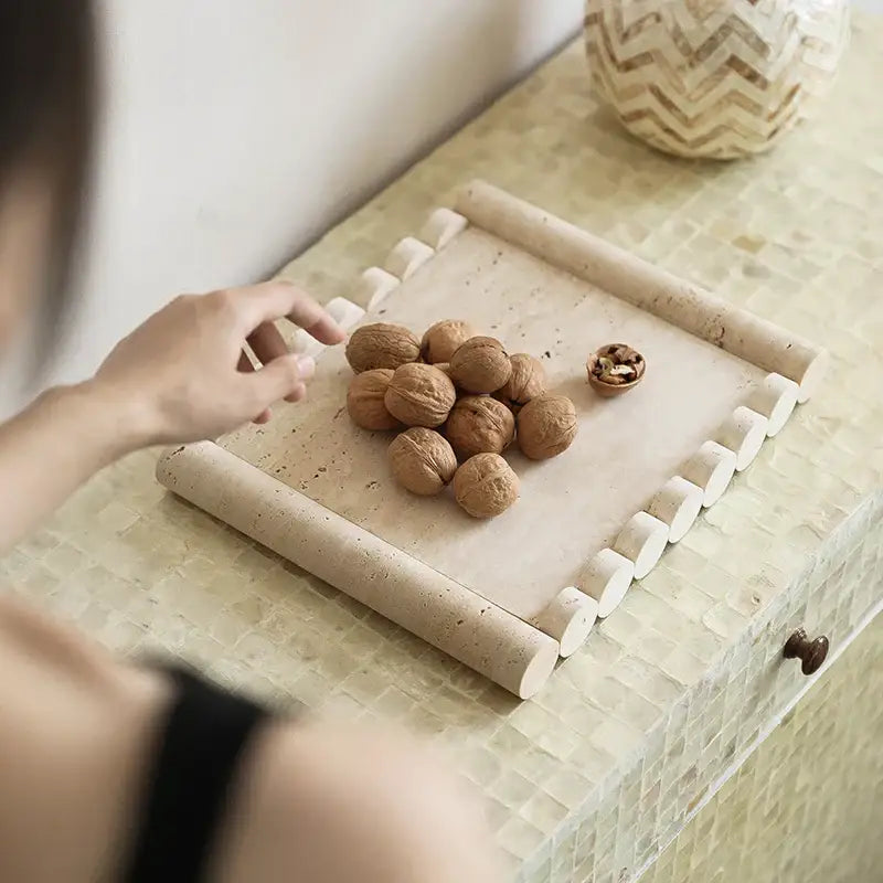Beige travertine marble serving tray with rolled edges and cylindrical handles for kitchen use