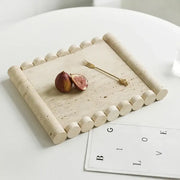 Beige travertine marble serving tray with rounded cylindrical edges and textured surface for kitchen use