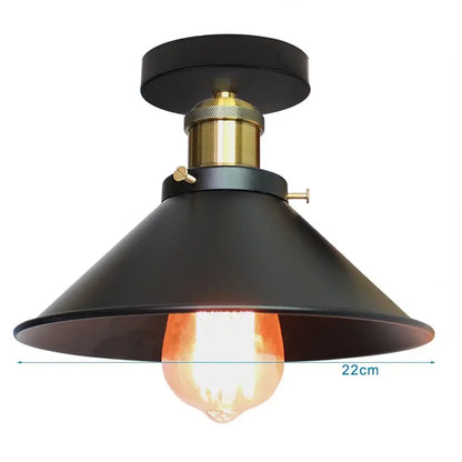 Vintage pendant light featuring black metal finish and brass accent with exposed edison bulb for kitchen island lighting