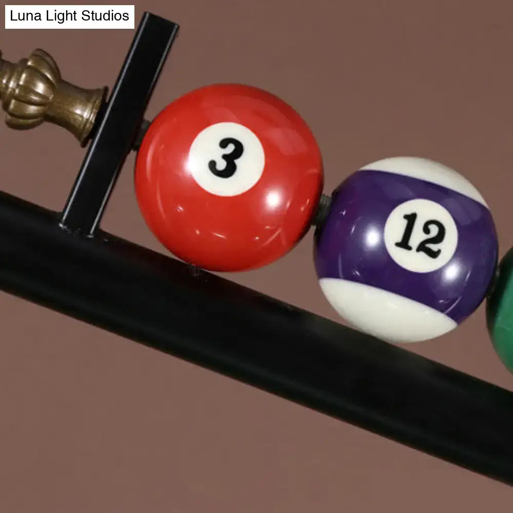 Red and purple pool balls with white numbers rest on a black rack under decorbites™ vintage style black metal ceiling light ideal for billiard room