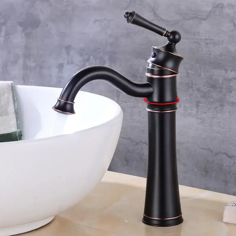 Vintage black and copper high arch basin faucet with single handle and matte finish beside white bowl sink