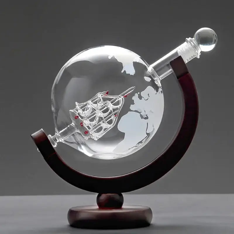 Vintage black earth decanter set featuring a clear glass globe with etched world map and miniature ship on wood stand
