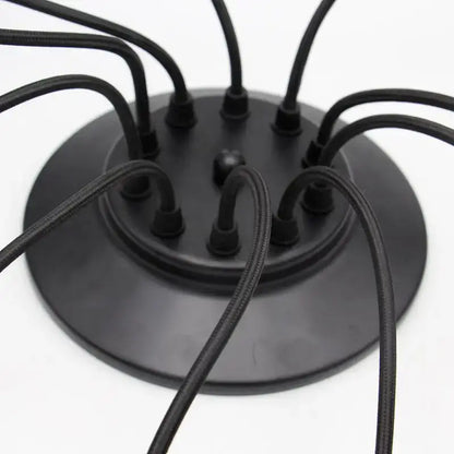 Vintage black industrial pendant chandelier with black finish and braided cords extending from the circular base