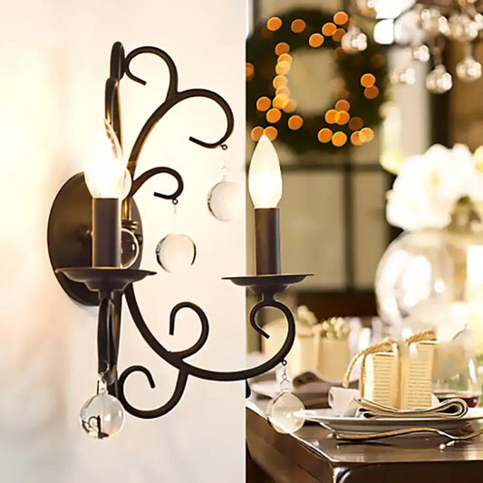 Vintage black wrought iron wall light with two candle-style bulbs and crystal ball deco for living room decor