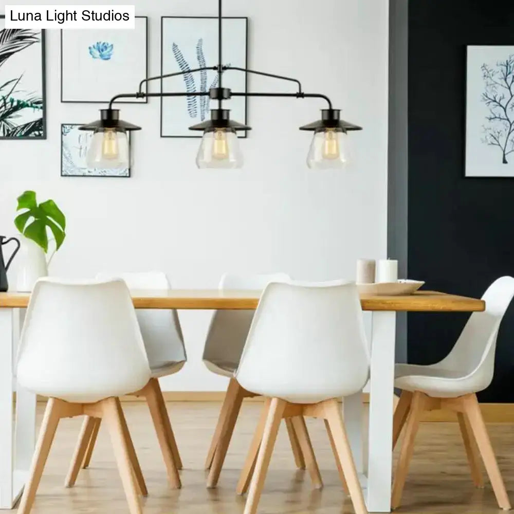 Black metal chandelier with three clear glass shades and exposed filament bulbs for clear glass island lighting