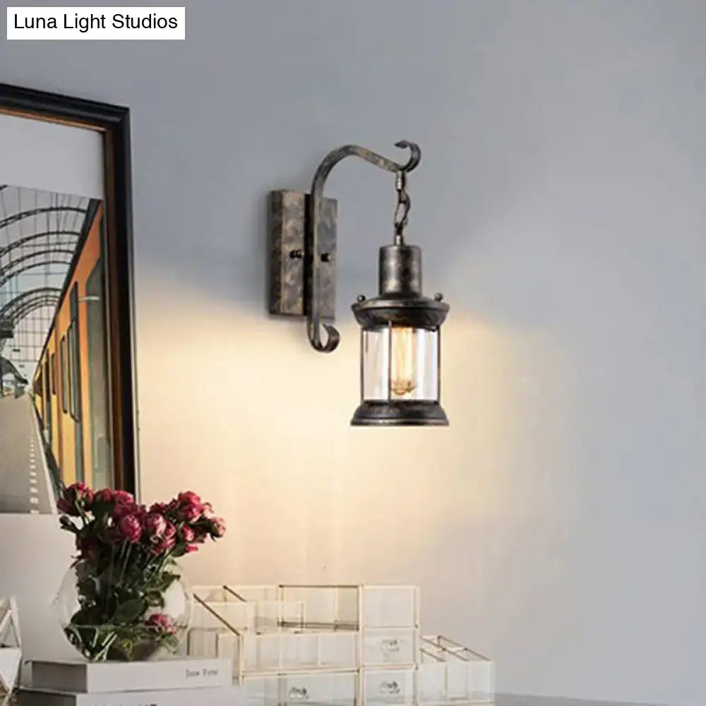 Antique bronze-finished light fixture with clear glass lantern and exposed bulb for dining room lantern wall sconce