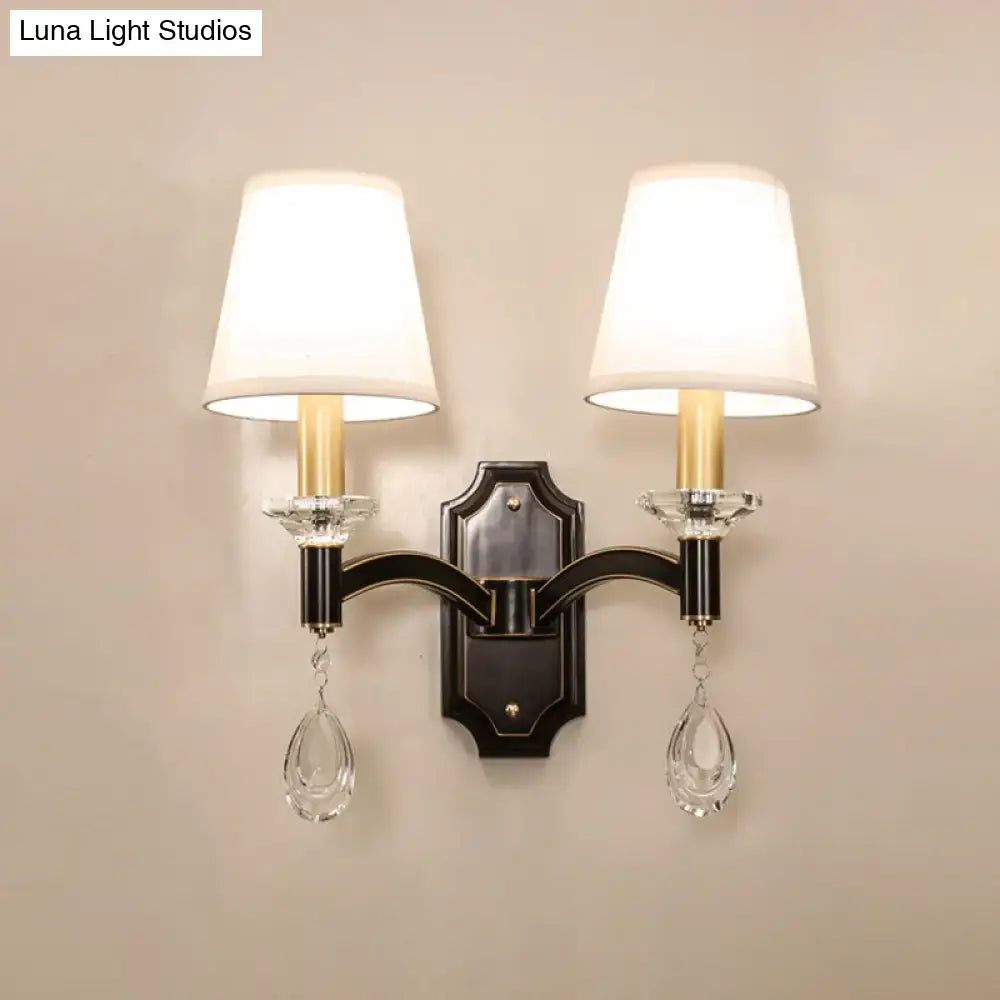 Elegant vintage black metal wall lamp with two white fabric shades and cut crystal teardrop pendants for bedroom use