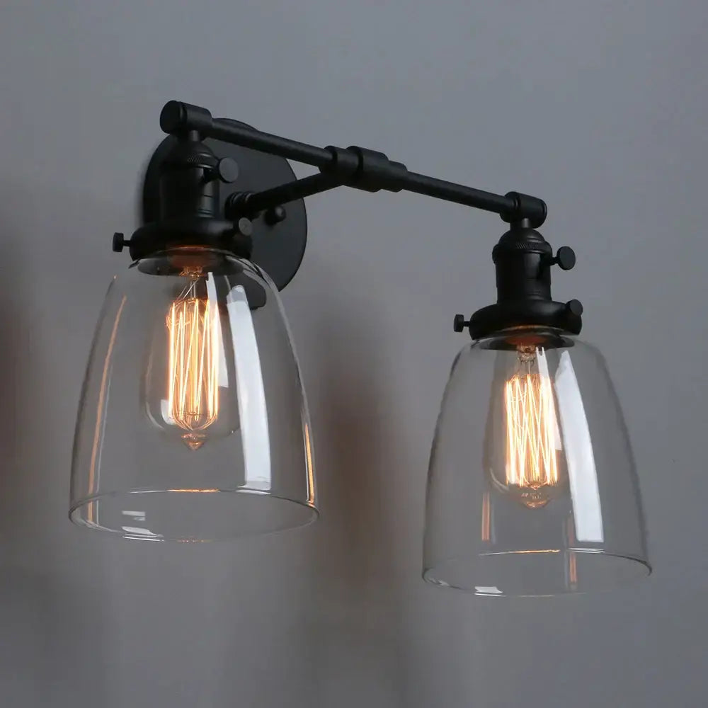Vintage black two light wall sconce with industrial metal frame and clear glass shades for bedroom lighting