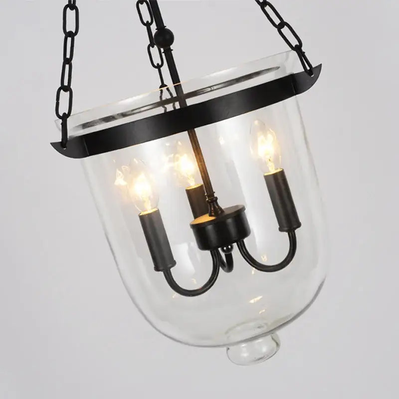 Black vintage pendant lamp with wrought iron frame clear glass enclosure and three exposed filament bulbs for dining room decorbites