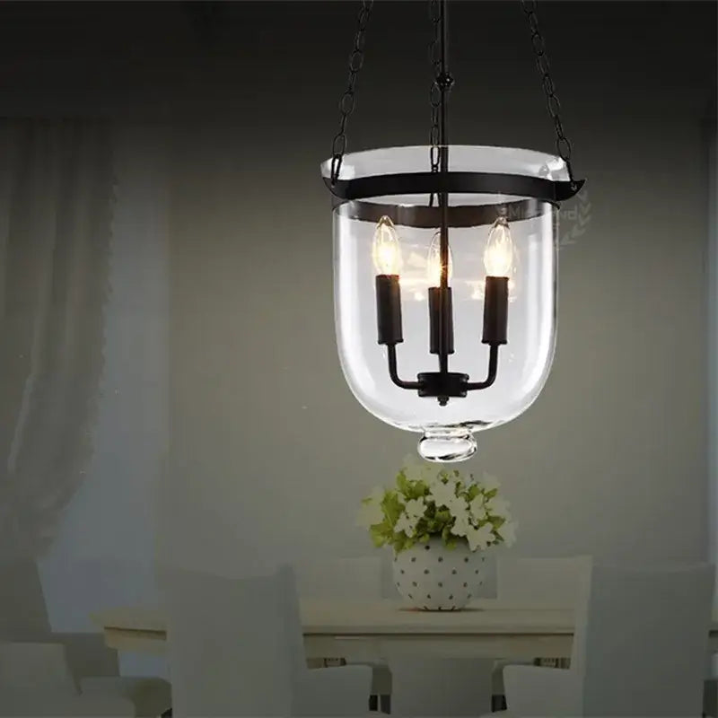 Black vintage pendant lamp with wrought iron frame and glass enclosure featuring three exposed filament bulbs for dining room decorbites pendant lamp