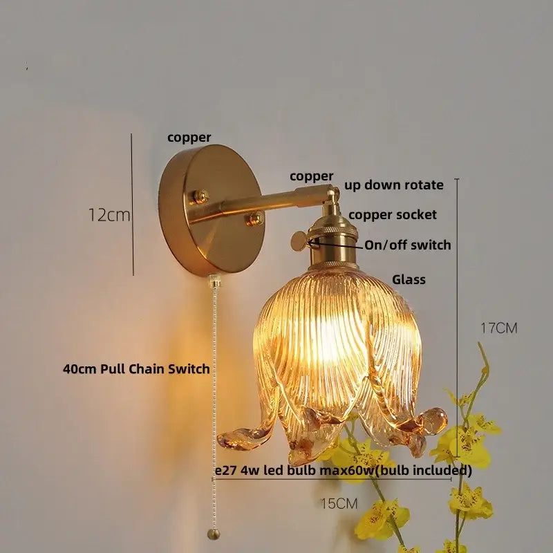 A warm-toned copper finished wall lamp with a ribbed glass floral shade for decorbites blue glass bedroom sconce