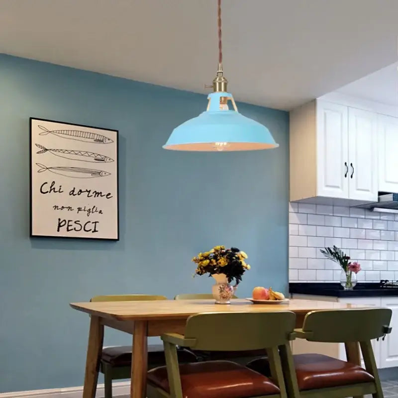 Vintage blue iron art pendant light with light blue industrial-style shade and brass hardware above dining table