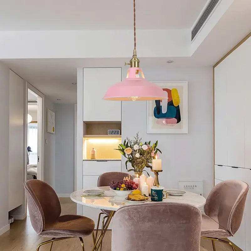 Pink pendant light with brass hardware above dining table complementing decorbites blue iron art pendant light