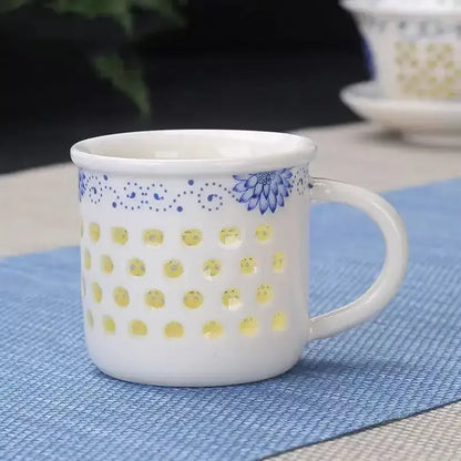 White ceramic tea cup with blue floral design and yellow circular cutouts from vintage blue and white cup set