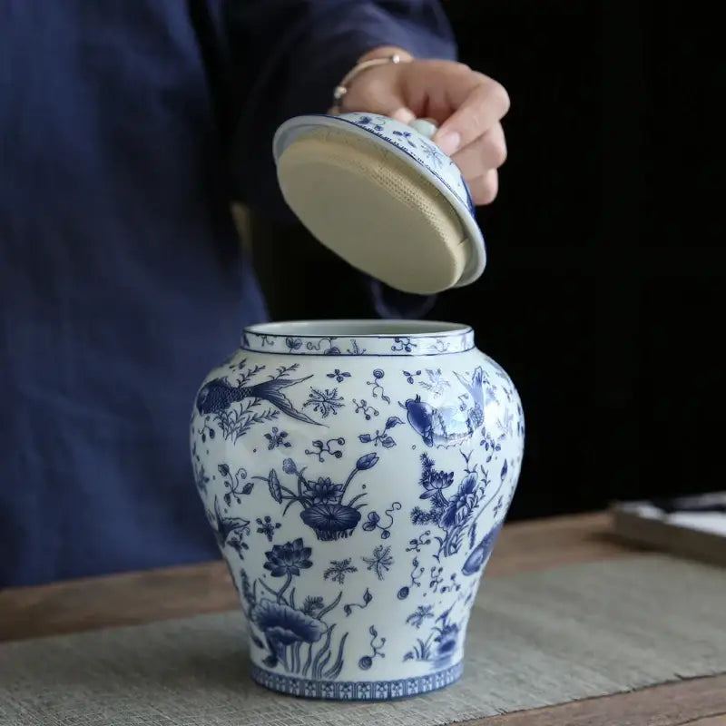 A vintage blue and white porcelain general jar with intricate floral bird motifs and matching lid lifted by hand decorbites blue