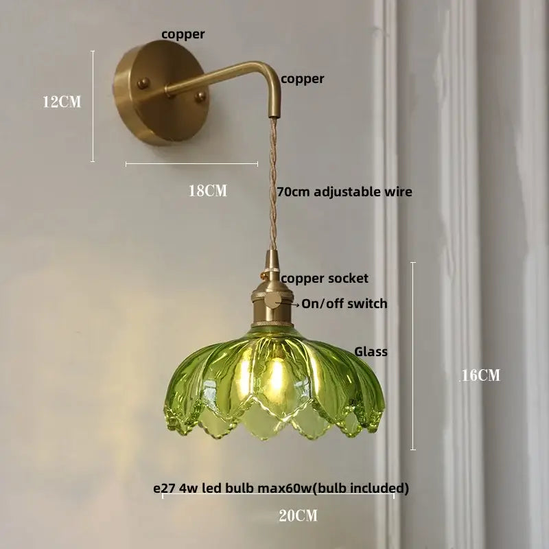 Vintage brass wall sconce with copper arm and adjustable wire featuring a green glass amber coffee glass lampshade