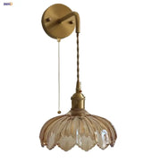 Vintage brass wall sconce with amber coffee glass petal-shaped shade and twisted cord for bedroom lighting