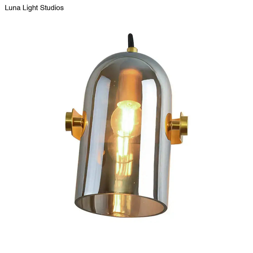 A vintage brass amber swivel shade cloche bedside sconce with chrome finish and warm glow from exposed bulb