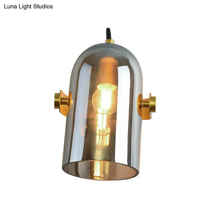 A vintage brass amber swivel shade cloche bedside sconce with chrome finish and warm glow from exposed bulb
