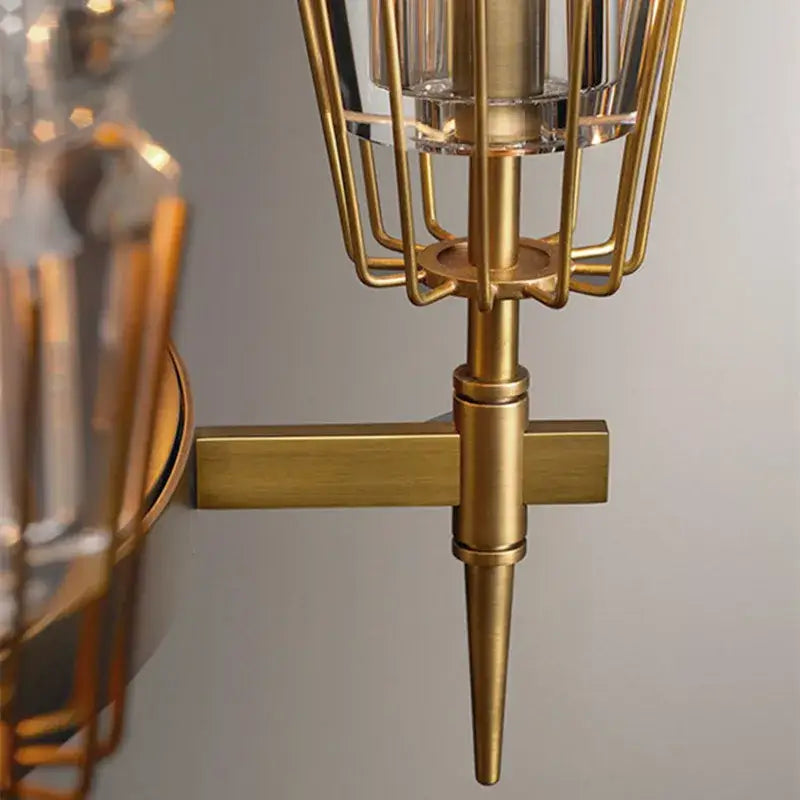 Gold-toned decorbites brass ana metal sconce with cage design and clear glass accents for vintage brass ana chandelier decor