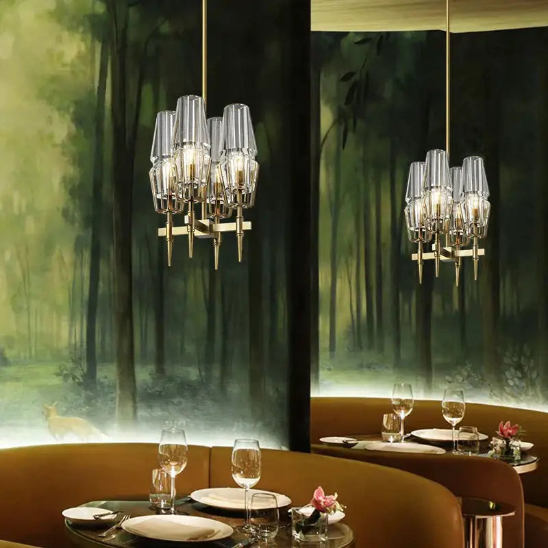 Modern décorbites brass ana chandelier featuring clear glass shades and gold-toned metal accents for dining room lighting