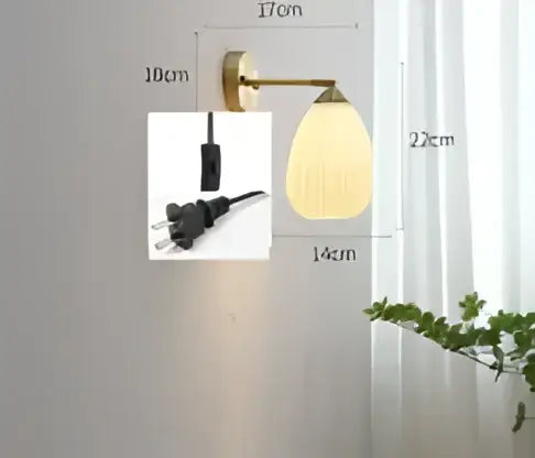 Vintage brass and amber glass led wall lamp with a curved arm and oval frosted glass shade for bedroom sconce lighting