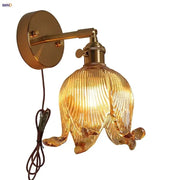 Golden brass wall light with loft amber glass ribbed shade shaped like an open flower for bedroom decorbites loft amber