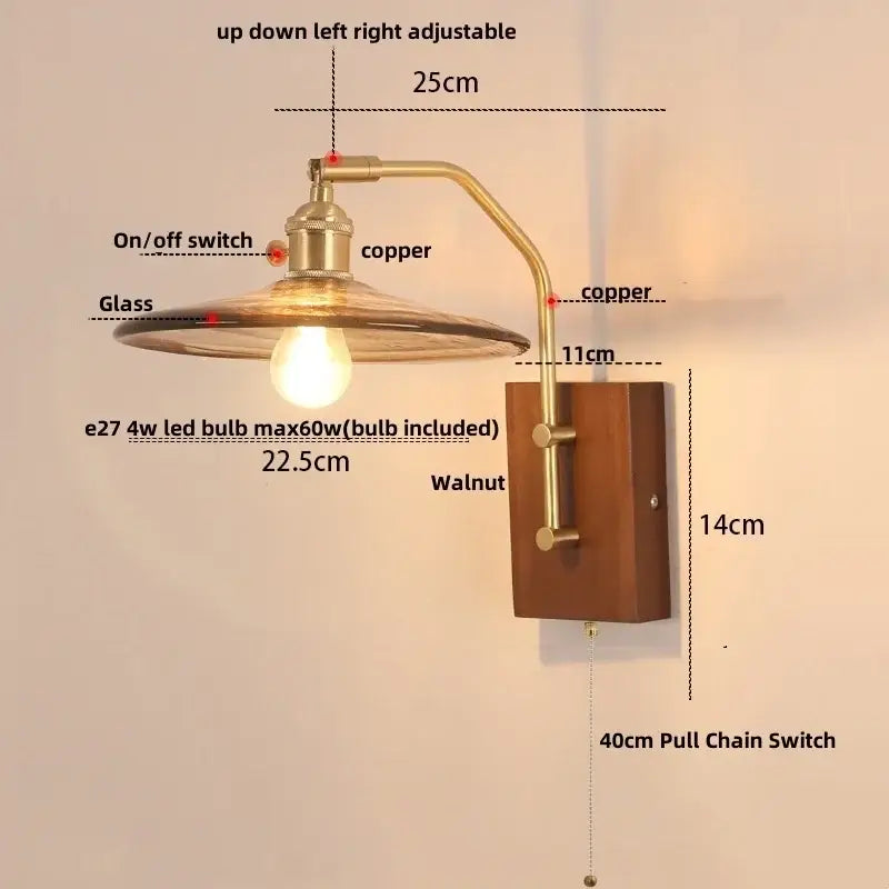 Copper-finished vintage brass wall sconce with amber glass shade, walnut mounting plate, and pull chain switch