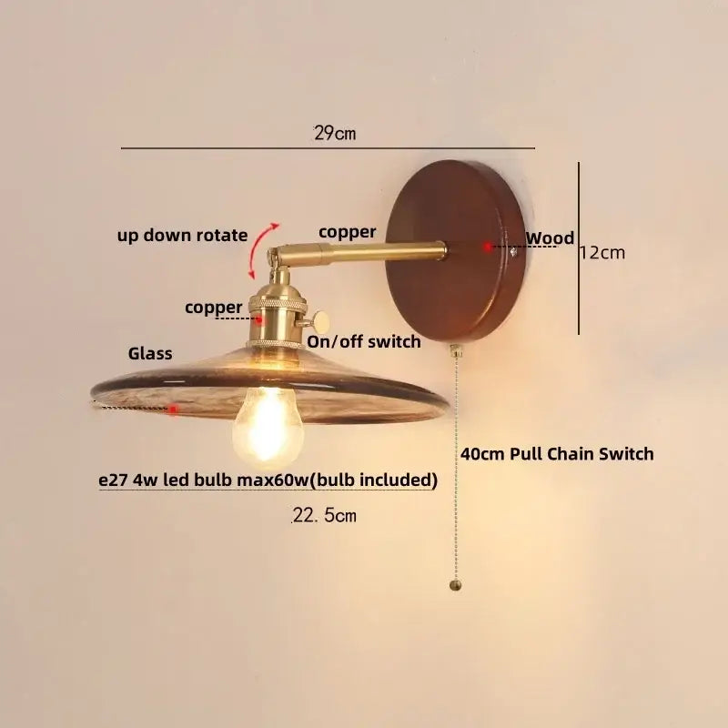 Vintage brass and amber glass wall sconce with copper finish and pull chain switch illuminating stair light