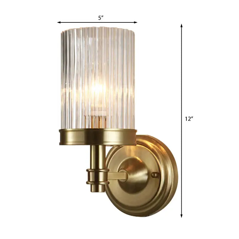 Vintage brass and black wall lamp with clear ribbed glass cylinder shade diffusing warm light for bedroom use