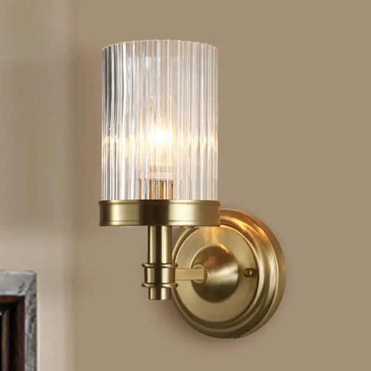Vintage brass wall lamp with clear ribbed glass cylinder shade and black accents for bedroom lighting