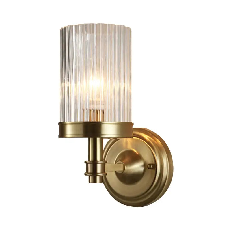 Vintage brass and black wall lamp with a clear ribbed glass cylinder shade for bedroom lighting