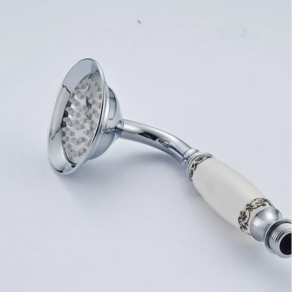 Chrome finished vintage brass and bronze hand shower head faucet set with off-white ceramic handle and ornate gold detailing