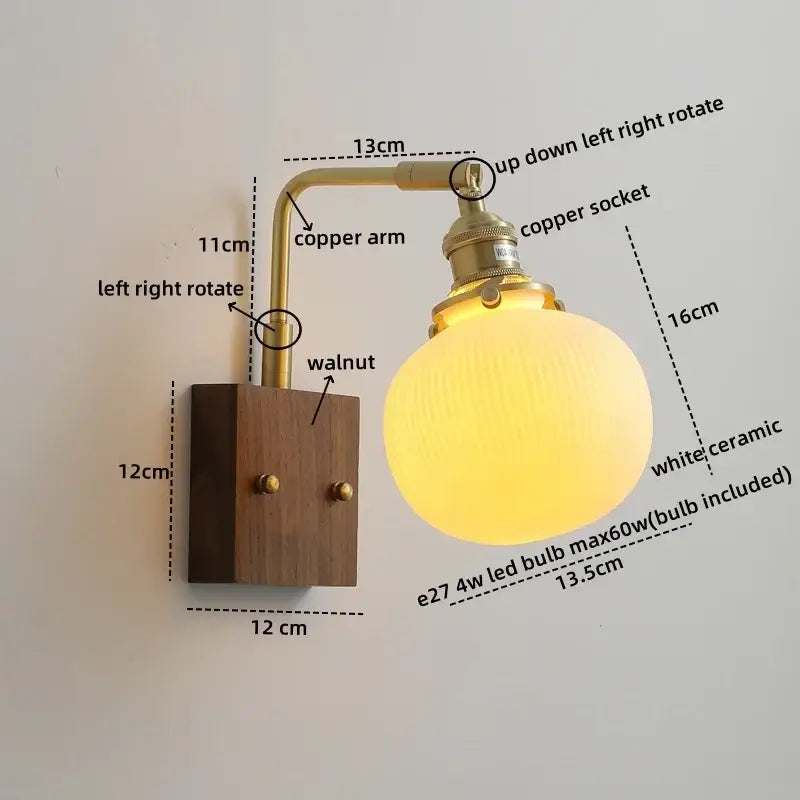 A warm glowing white ceramic led wall light with a vintage brass arm and walnut base for bedroom use