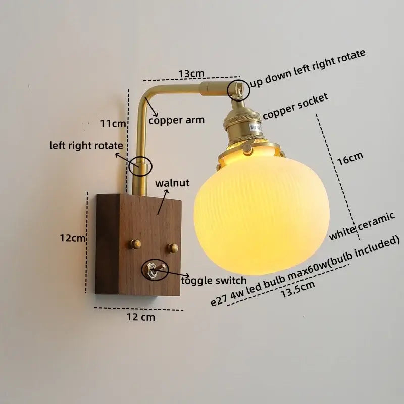 A warm glowing vintage brass and ceramic led wall light with walnut wood base and pull chain for bedroom use