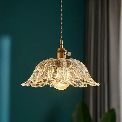 Vintage brass and clear glass pendant light with a delicate fluted floral shade and polished copper hardware for kitchen use