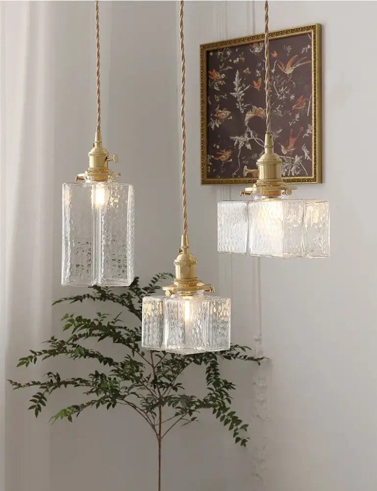 Vintage brass pendant light with three clear glass textured shades and polished copper twisted cord suspensions