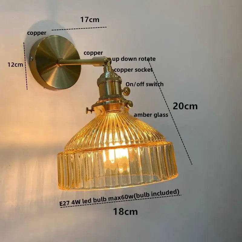 Vintage brass wall lamp with ribbed amber glass shade and pull chain switch for bedroom use with clear glass detail