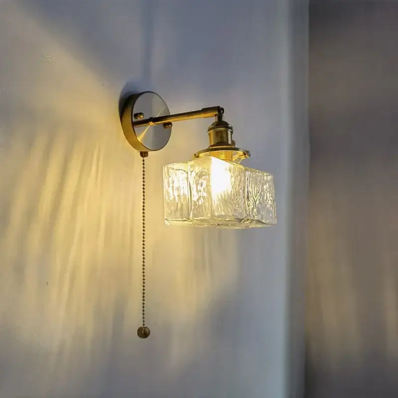Vintage brass and glass led wall lamp with textured clear glass cube shade and pull chain for bedroom lighting
