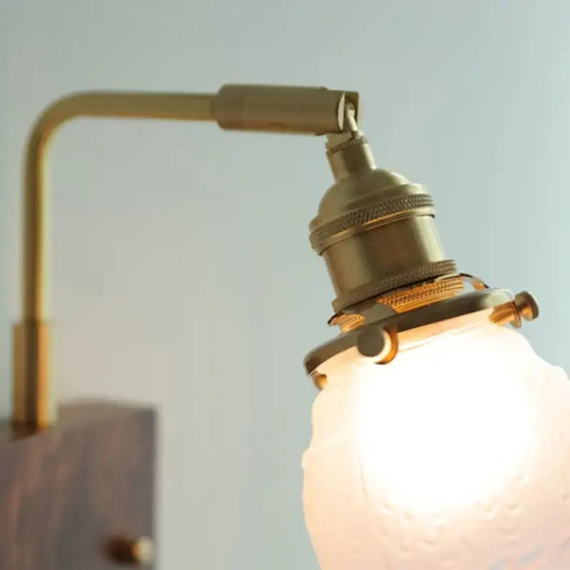 Vintage brass and glass pink led wall lamp with adjustable arm and frosted globe bulb for bedroom sconce lighting