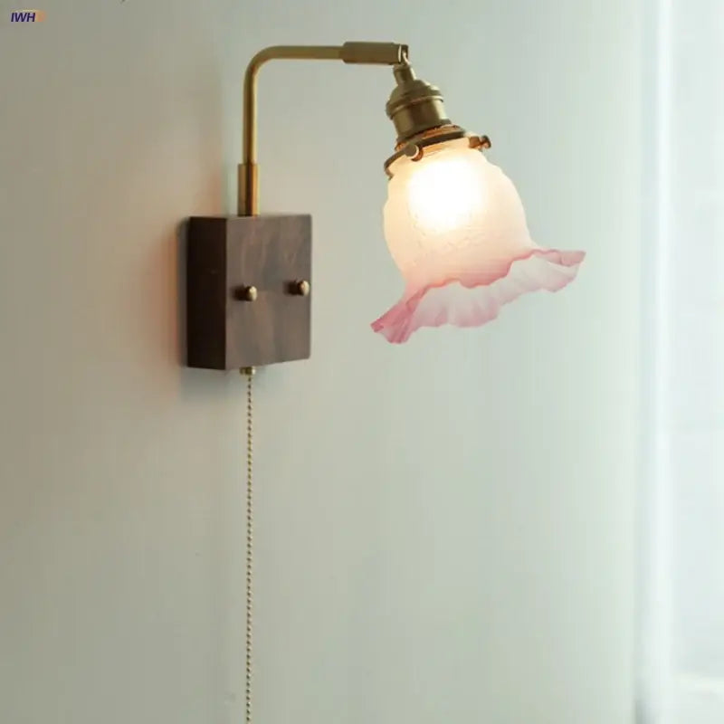 Vintage brass wall lamp with a glass pink led shade featuring ruffled edges for bedroom sconce lighting