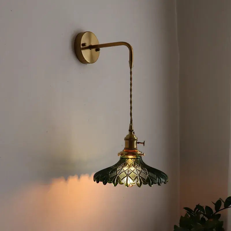 Antique brass led wall lamp with dark green leaf-shaped glass shade featuring intricate cut patterns for living room