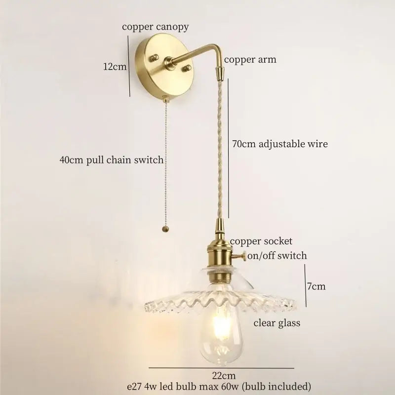 Antique brass-finished wall light with clear glass led shade and copper components for bedroom use