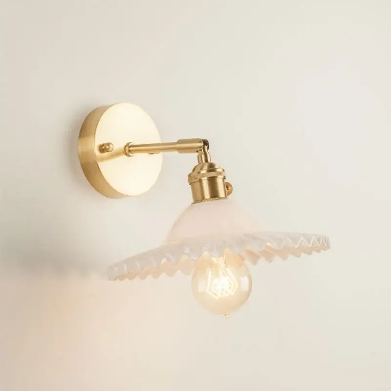 Vintage brass wall light with frosted scalloped glass led shade and exposed bulb for bedroom use