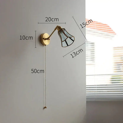 Brass-finished wall lights with green glass led shade featuring black geometric patterns and adjustable arm for bedroom use