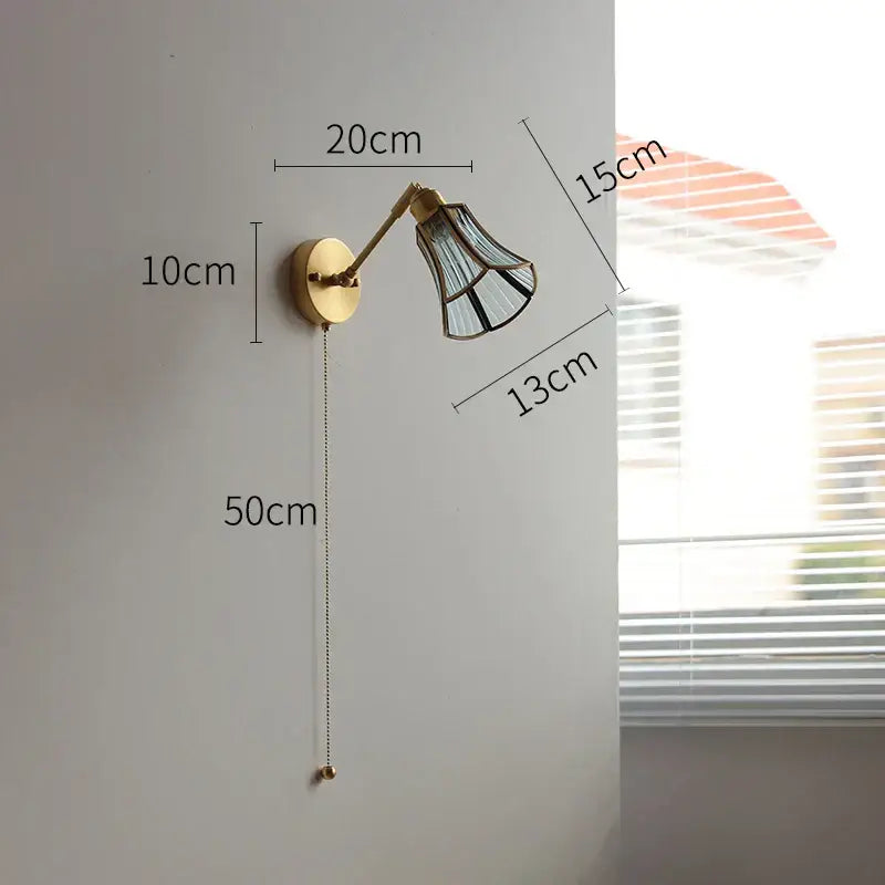 Brass-finished wall lights with green glass led shade featuring black geometric patterns and adjustable arm for bedroom use